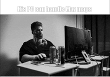 a black and white photo of a man sitting at a desk in front of a computer with the caption " his pc can handle maz maps "