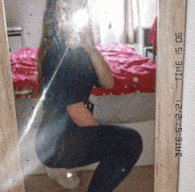 a girl taking a picture of herself in a mirror with a date stamp of 12/06