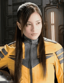 a woman with long hair is wearing a yellow and gray uniform