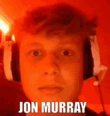 a young man wearing headphones with the name jon murray written on his face