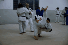 a group of men are practicing judo in a gym with one man wearing a black belt that says ' aoi '