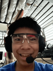 a boy wearing headphones and safety glasses smiles for the camera