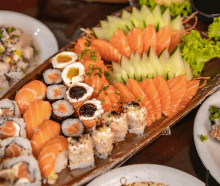 a variety of sushi and vegetables on a wooden tray