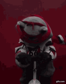 a teddy bear in a ninja turtle costume is riding a bicycle .