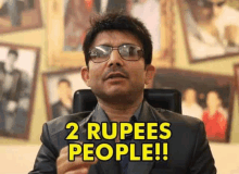 a man in a suit and glasses is sitting in front of a wall with pictures and says `` 2 rupees people ! ''