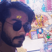 a man with a beard wearing sunglasses has a yellow sticker on his forehead that says ' jd '