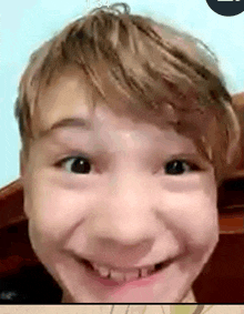 a close up of a young boy making a funny face while talking on a video call .