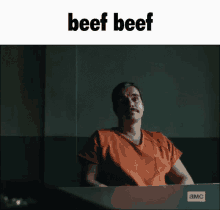 a man in an orange prison uniform is sitting at a table with the word beef beef above him