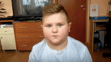 a boy is sitting in front of a tv in a room with a sign on the wall that says 2 days