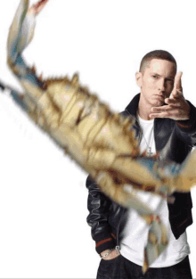 a man in a leather jacket holds a large crab in his hand