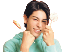 a young man in a blue hoodie is holding a lollipop