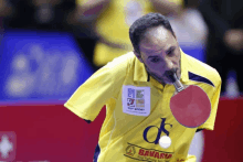 a man playing ping pong with a shirt that says egy sport on it