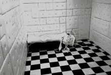 a black and white photo of an empty room with a checkered floor