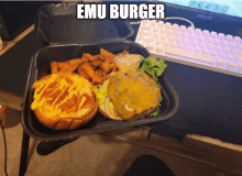 a hamburger and french fries in a styrofoam container that says " emu burger "