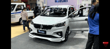 a white suzuki car is on display at a show