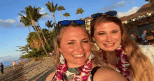 two women are posing for a picture on the beach