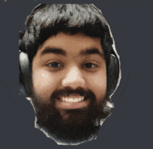 a man with a beard wearing headphones smiles for the camera