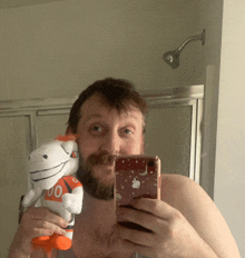 a shirtless man is taking a selfie with a stuffed animal with the number 00 on it