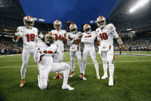 a group of football players posing for a picture with one wearing the number 18