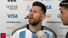 a soccer player is talking into a microphone while standing next to a man .