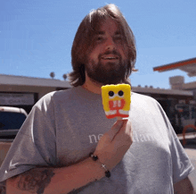 a man with a beard is holding a spongebob popsicle