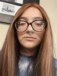 a girl wearing glasses looks at the camera with a picture of a church in the background