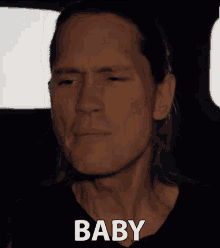 a close up of a man 's face with the word baby written below it