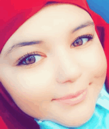 a close up of a woman 's face with a red head scarf