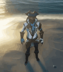 a man in a pirate costume is standing on a beach near the water .