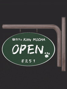 a green sign that says kitty mocha open on it