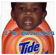 a baby is sitting on top of a tide laundry detergent bottle .