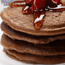 a close up of a stack of pancakes with syrup on top and the words jarabe de al gusto on the bottom