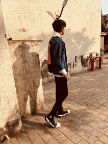 a young man wearing a denim jacket with a sticker on the back that says ' i love you '