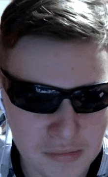 a close up of a man wearing sunglasses and earphones