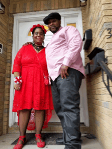 a man in a pink shirt and a woman in a red dress pose for a picture