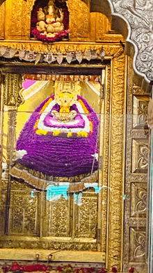 a purple and white statue of a deity with a crown