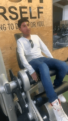 a young man is sitting on a machine in a gym .