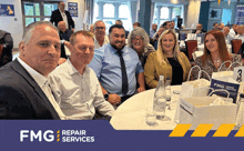 a group of people are sitting at a table with fmg repair services written on the bottom