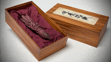 a wooden box with chinese writing on it and a purple cushion