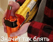 a person is holding a nerf gun with russian writing on the bottom