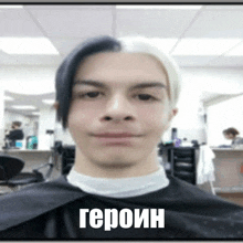 a man with half black and half white hair is sitting in a chair in a salon