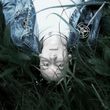 a person with a pentagram on their jacket laying in the grass