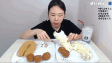 a woman sits at a table with plates of food and a starbucks drink with a freecat logo in the corner