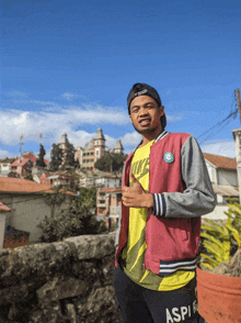 a man wearing a pink nike jacket stands in front of buildings