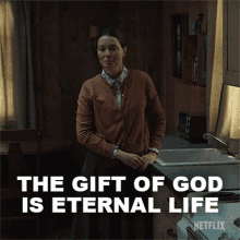 a woman standing in a kitchen with the words " the gift of god is eternal life " above her