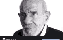 a black and white photo of an older man with a beard and a memepedia logo in the corner