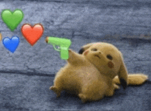 a stuffed animal is holding a green gun with hearts behind it