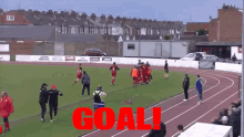 a group of soccer players on a field with the word goal in red