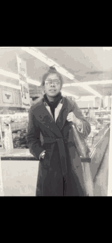 a black and white photo of a woman standing in a store