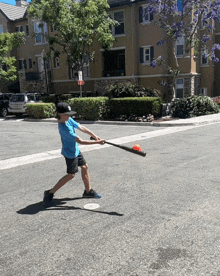 a young boy is swinging a bat at a ball